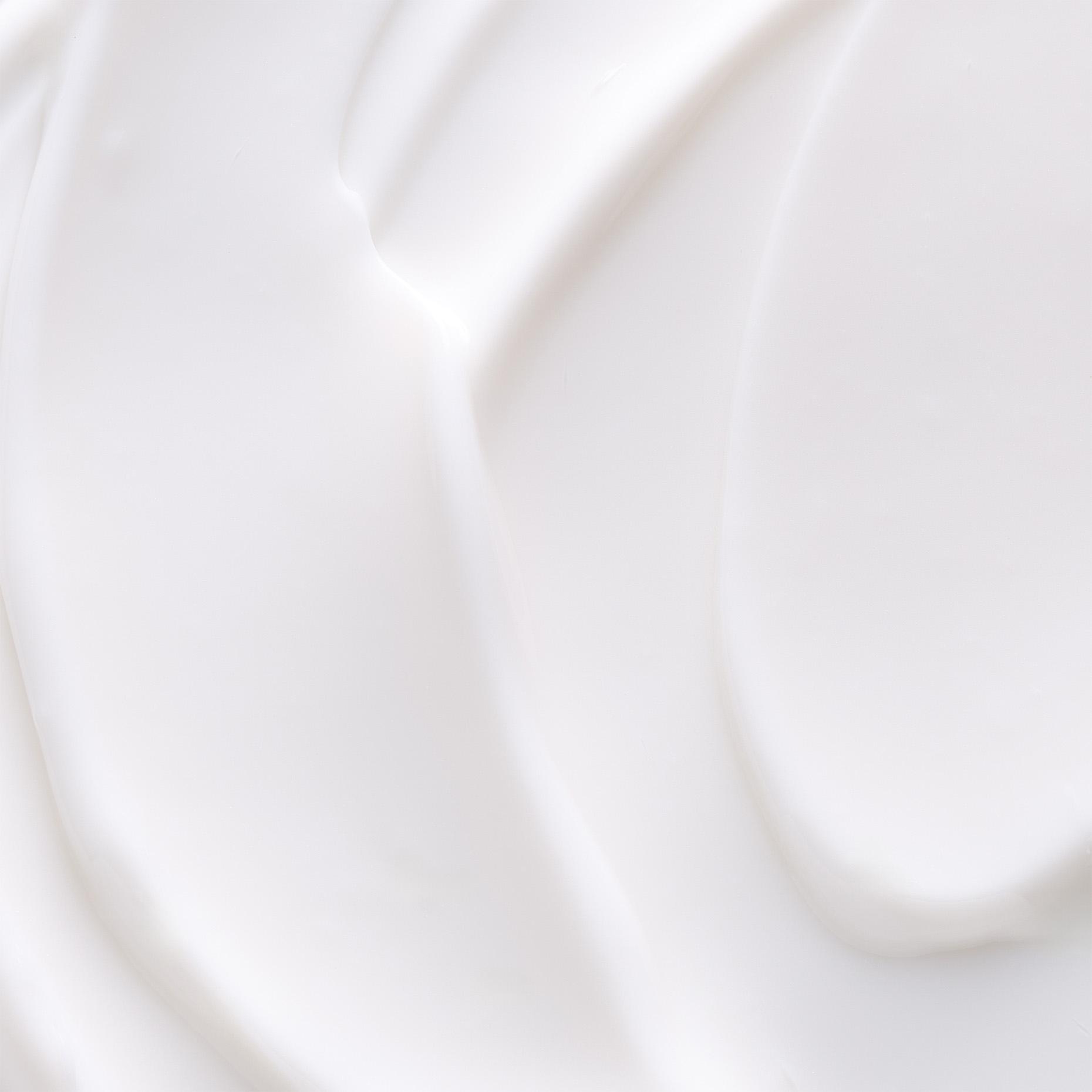 Close-up of white cream with soft, flowing curves and highlights.