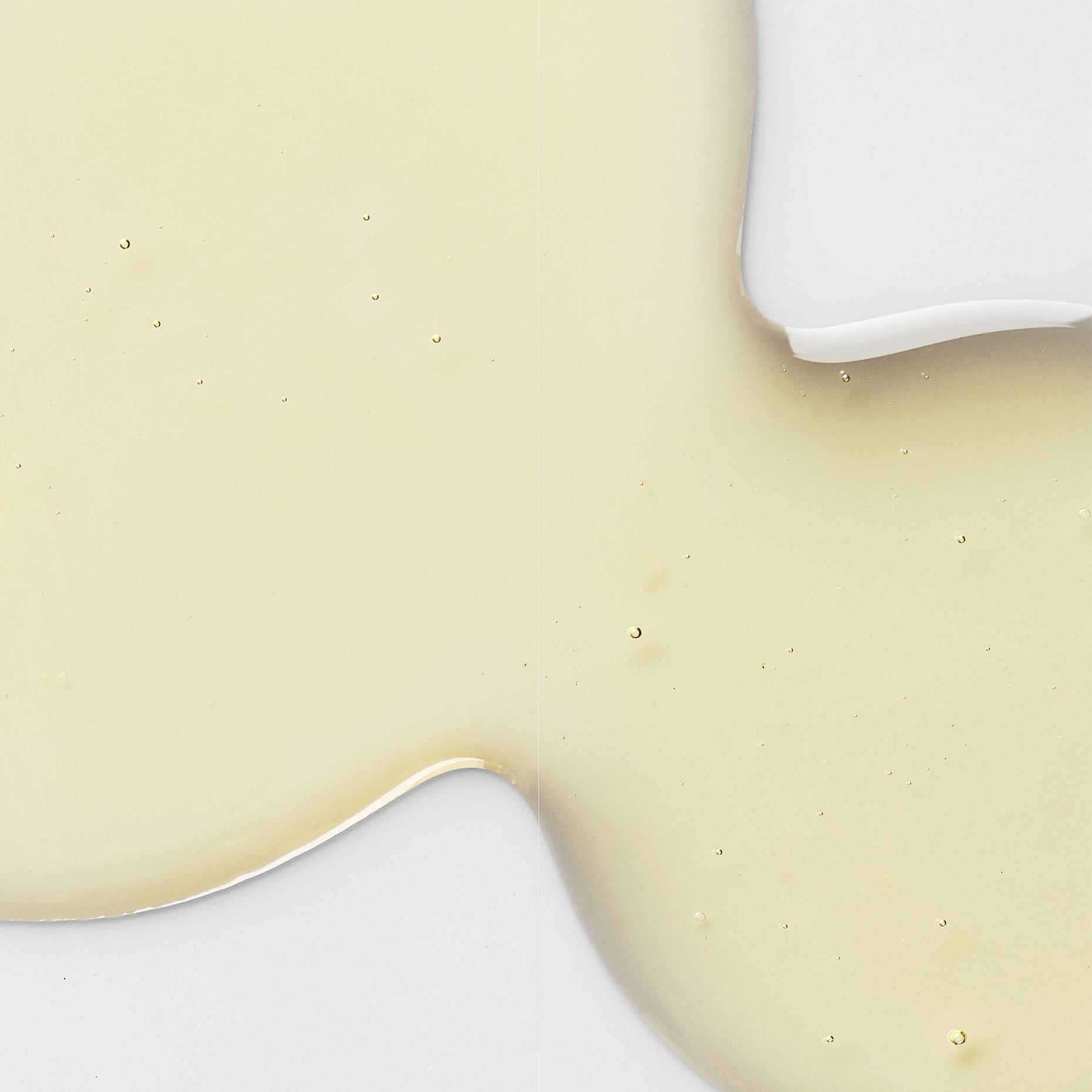 Light yellow liquid with small bubbles on a white background.